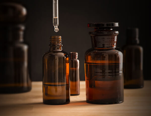 Ingredients Dropping liquid Ingredientsfrom Eye Dropper into Brown Bottle